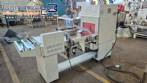 L-shaped packaging sealer with semi-automatic shrink tunnel.